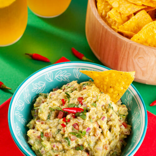 Guacamole saudável finalizado com textura cremosa e pedaços de tomate e cebola